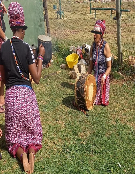 Figure 6. Amagqirha performing the igubu drum during an initiation ceremony.